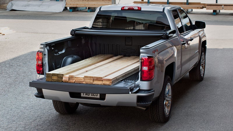 A Chevy Silverado at a lumber yard with some wooden planks in the back of the truck bed