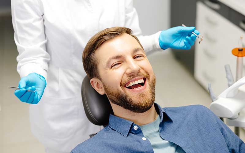 A man in the dental chair smiling