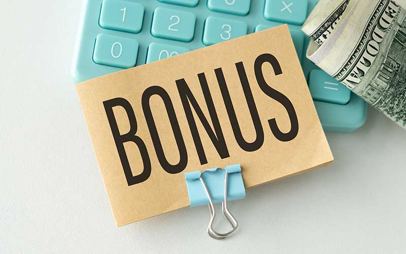 The word bonus written on an envelope layed ontop of a calculator